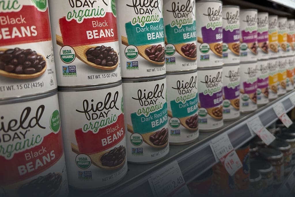 Row of canned beans on a shelf